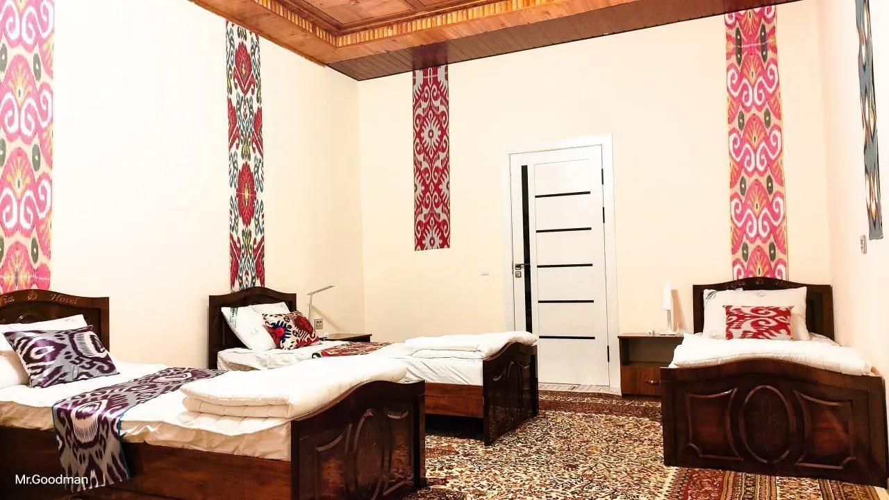 Shared room with three beds and ikat panels on the walls